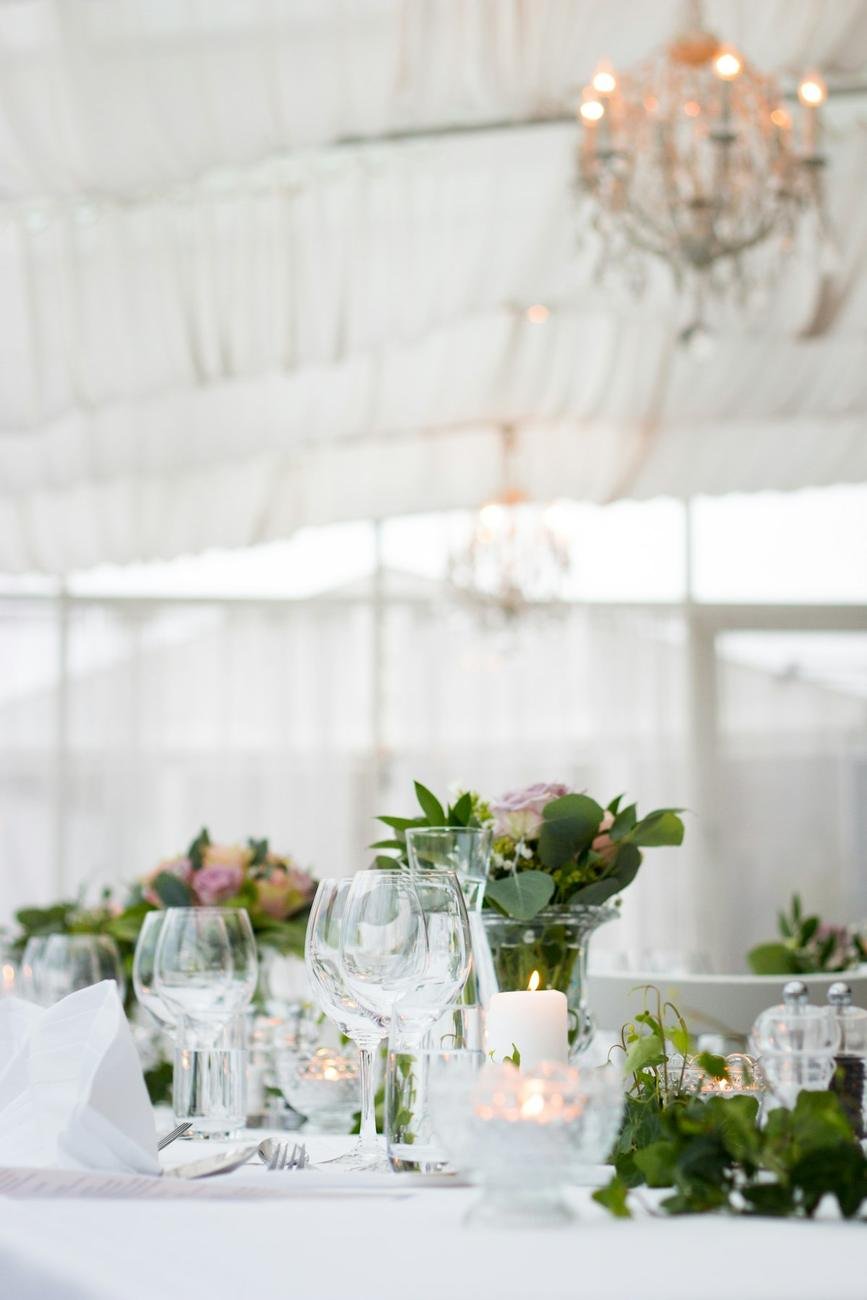 Mesa de boda bajo una carpa con lámpara de araña