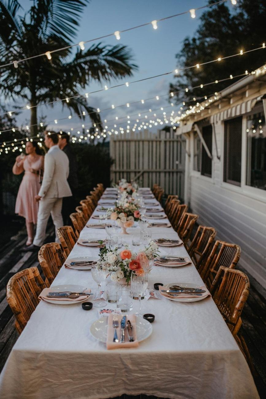 Mesa larga de boda al aire libre con luces