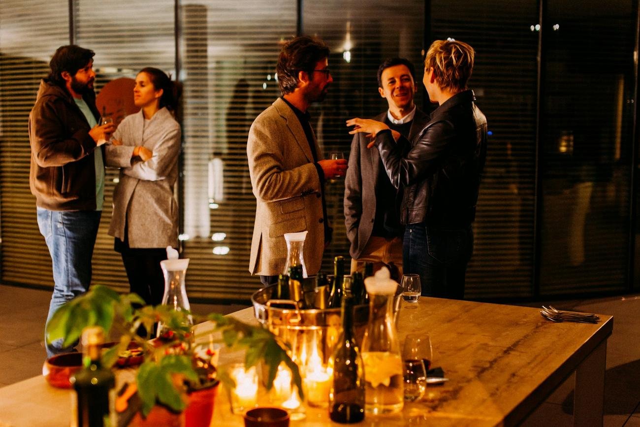 Profesionales conversando con una copa en un evento de empresa