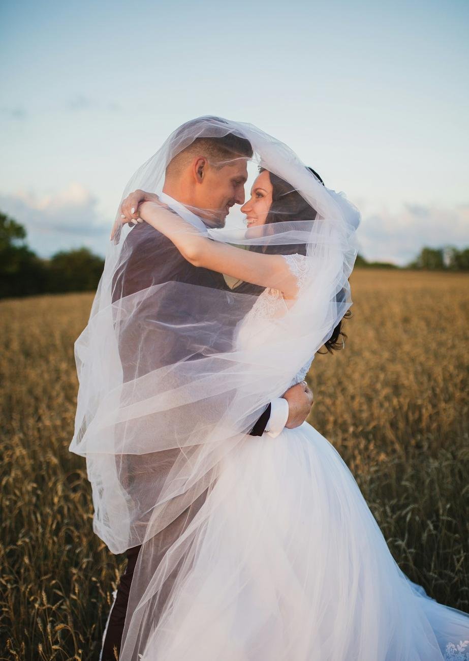 Pareja de novios a punto de besarse en el campo